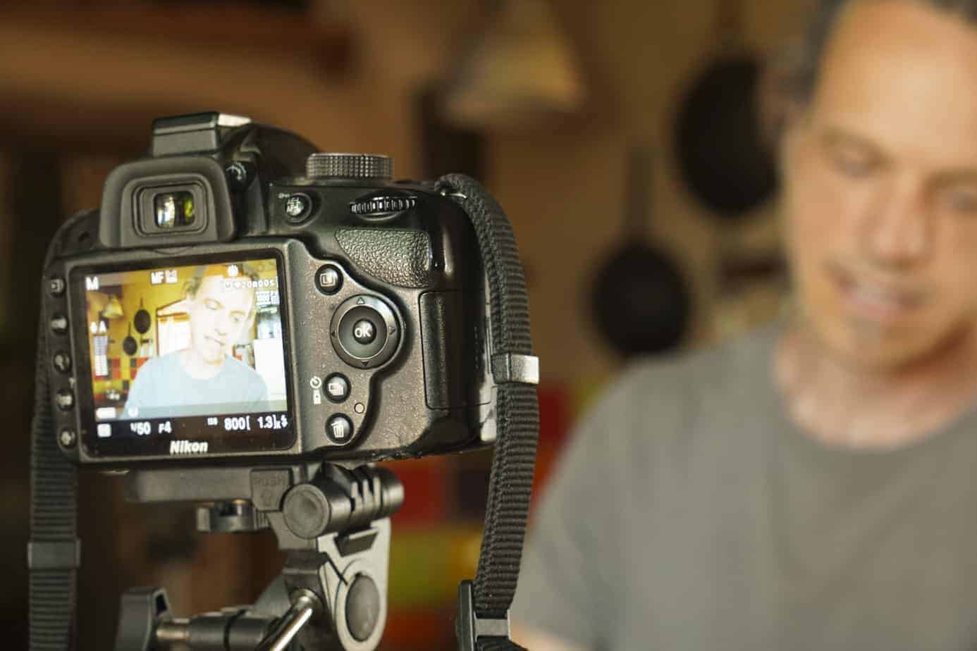 Fotografía de un hombre grabando un video sobre alimentación consciente con una cámara profesiona.