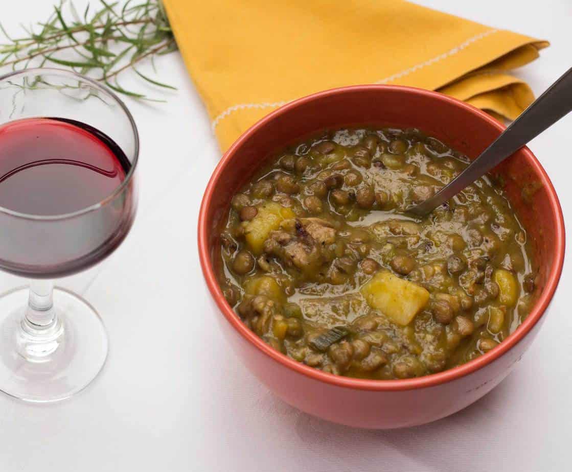 Guiso de lentejas en cuenco con vino tinto y hierbas, ideal para una alimentación consciente y equil.