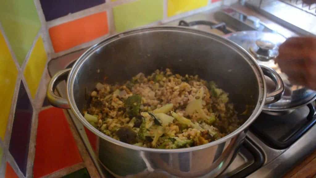 Preparación de comida saludable con verduras y carne en olla grande.