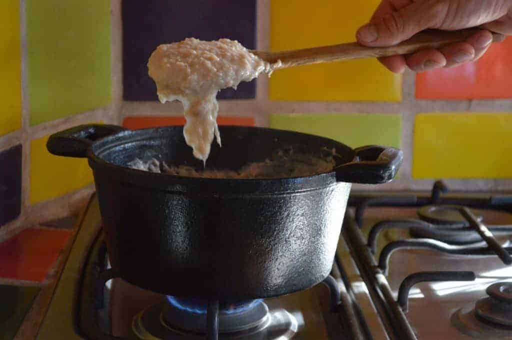 Persona cocinando comida saludable en olla sobre la estufa.